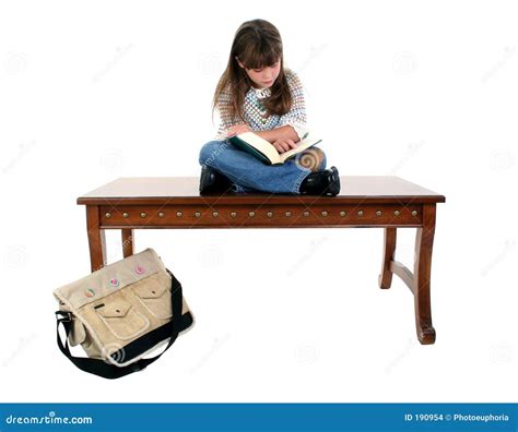 A Red Book Sitting On Top Of A White Table Next To An Open Book With