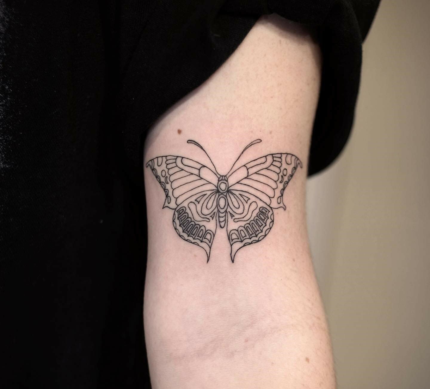 A Red Butterfly Tattoo On The Arm Of A Woman S Left Arm In A Store