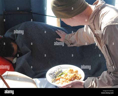 A U S Coast Guardsman Offers Food To An Iranian Mariner Stock Photo Alamy