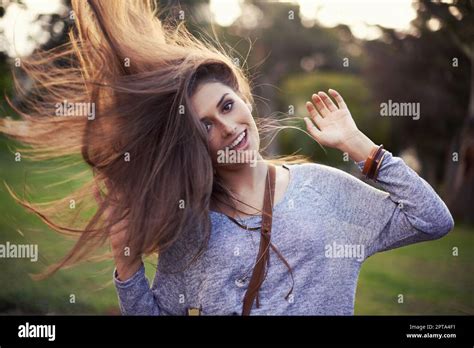 Portrait Of Pretty Young Woman Flinging Long Brown Hair Into Air In